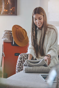 Portrait of young woman sitting on sofa at home