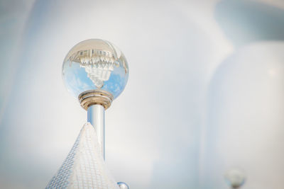 White buddha statues at wat pha sorn kaew reflecting on glass ball