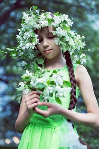 Low section of woman holding flowering plant