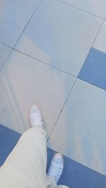 Low section of woman standing on tiled floor