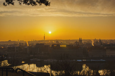 Prague tv tower at sunrise wirh roofs and birds flying