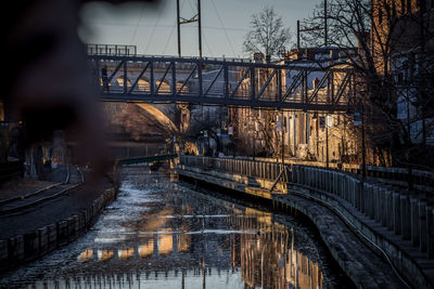 Bridge over river in city against sky