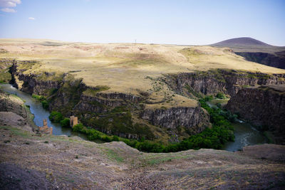 Scenic view of river by mountains against clear sky