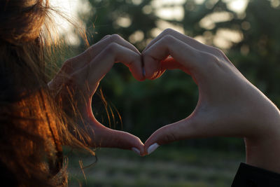 Close-up of woman hands with love heart shape. 