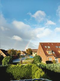 Houses by trees against sky