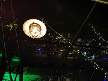 Low angle view of illuminated lighting equipment hanging on ceiling