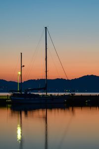 Boats in sea at sunset