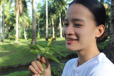 Close-up of young woman holding plant