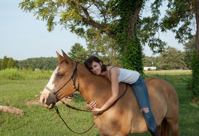 Portrait of smiling woman relaxing on horse 