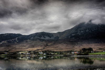 Scenic view of lake by mountains against sky