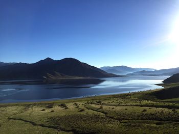 Scenic view of lake against clear blue sky