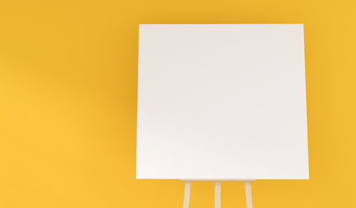 Low angle view of empty paper against yellow background