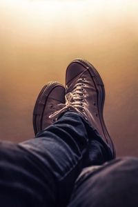 Low section of person relaxing against wall