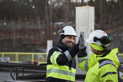 Construction engineers high-fiving at construction site