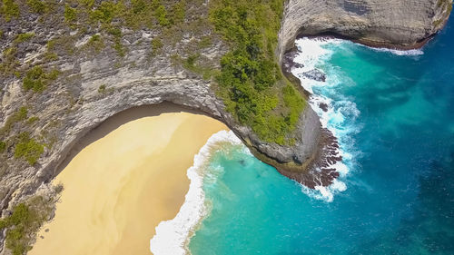 Top view aerial shot of sandy clean beach with blue and turquoise water. nusa penida, kelingking 