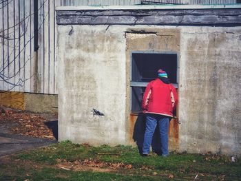 Rear view of woman walking against building