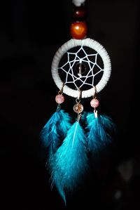 Close-up of feather hanging against black background