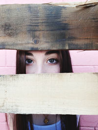 Close-up portrait of young woman hiding outdoors