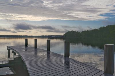 Wooden pier on lake against sky