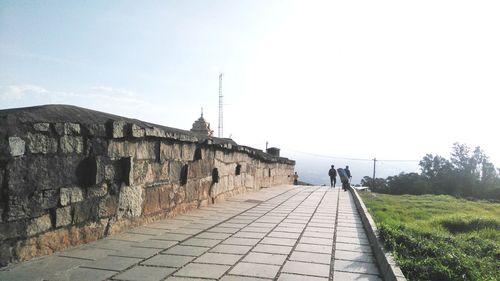 Footpath amidst buildings against sky