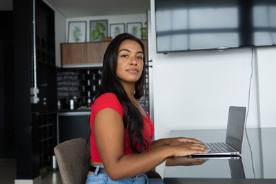 Young black woman working at home with laptop on desk. home office concept. gray notebook. 