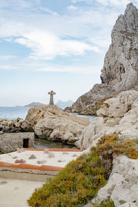 Rock formations by sea against sky