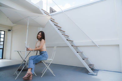 Side view of young woman sitting on seat