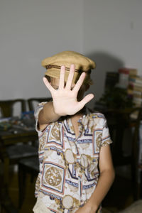 Boy with hand in front of face