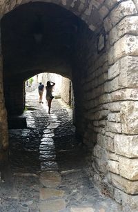 Rear view of people walking in tunnel