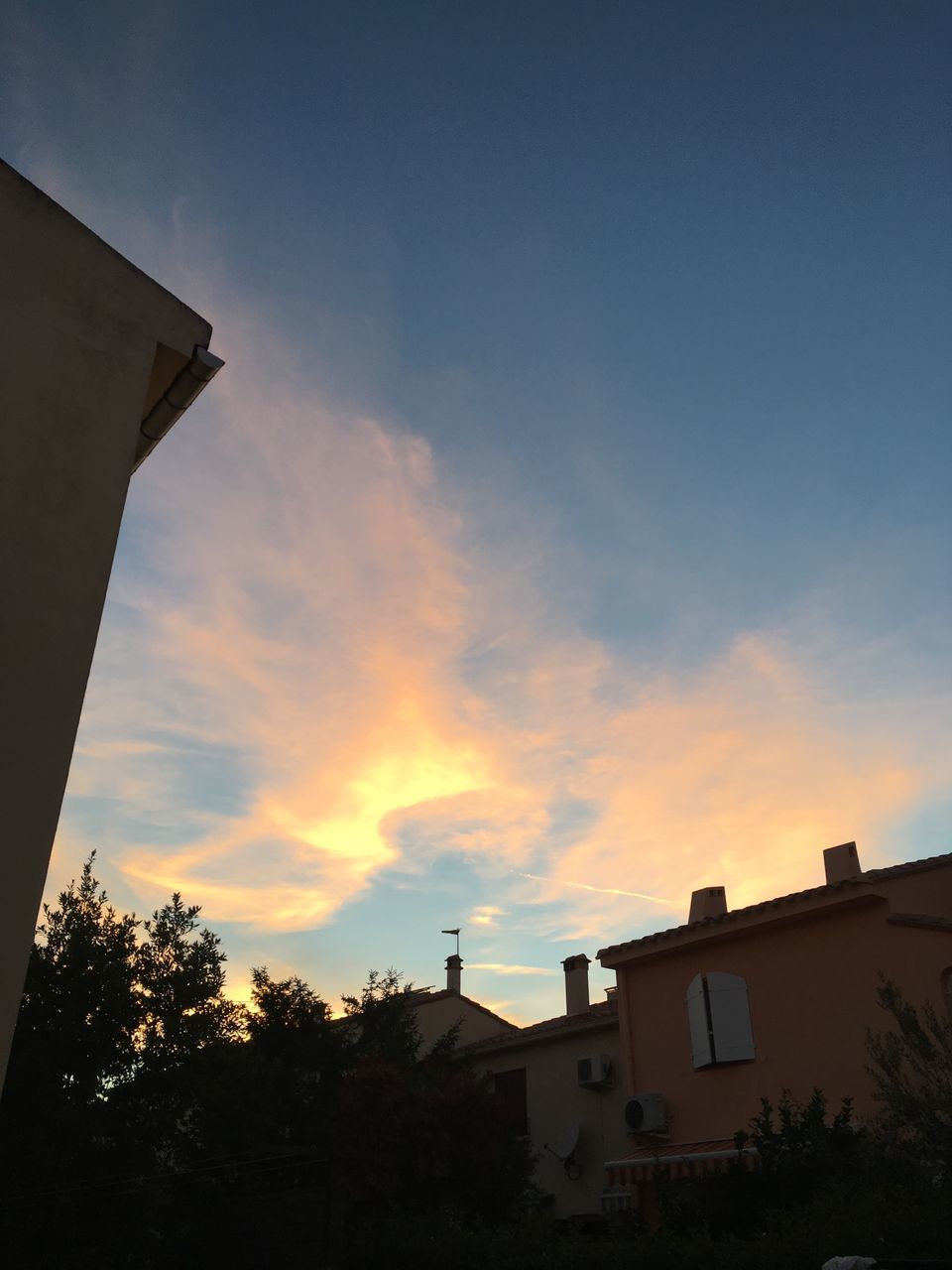 architecture, built structure, tree, building exterior, sunset, low angle view, cloud, sky, high section, outdoors, no people, cloud - sky, town, long, scenics, city life, atmospheric mood, tranquility, tranquil scene