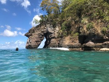 Scenic view of rocks in sea against sky