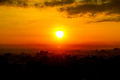 Silhouette buildings against sky during sunset