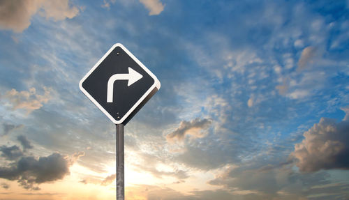 Low angle view of road sign against sky