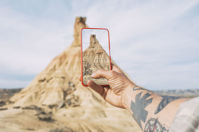 Taking photos with a smartphone of a castil de tierra peak, close-up shot