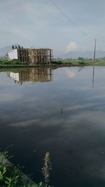 Scenic view of lake by building against sky