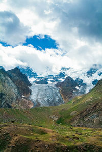 Scenic view of mountains against cloudy sky