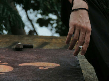 Close-up of person holding hands on cemetery