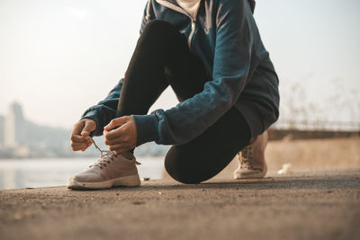 Low section of woman sitting outdoors