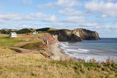 Fall landscape with beach and pretty traditional houses perched on cliff 