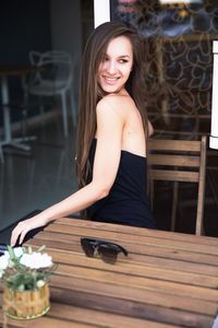 Portrait of a smiling young woman sitting outdoors