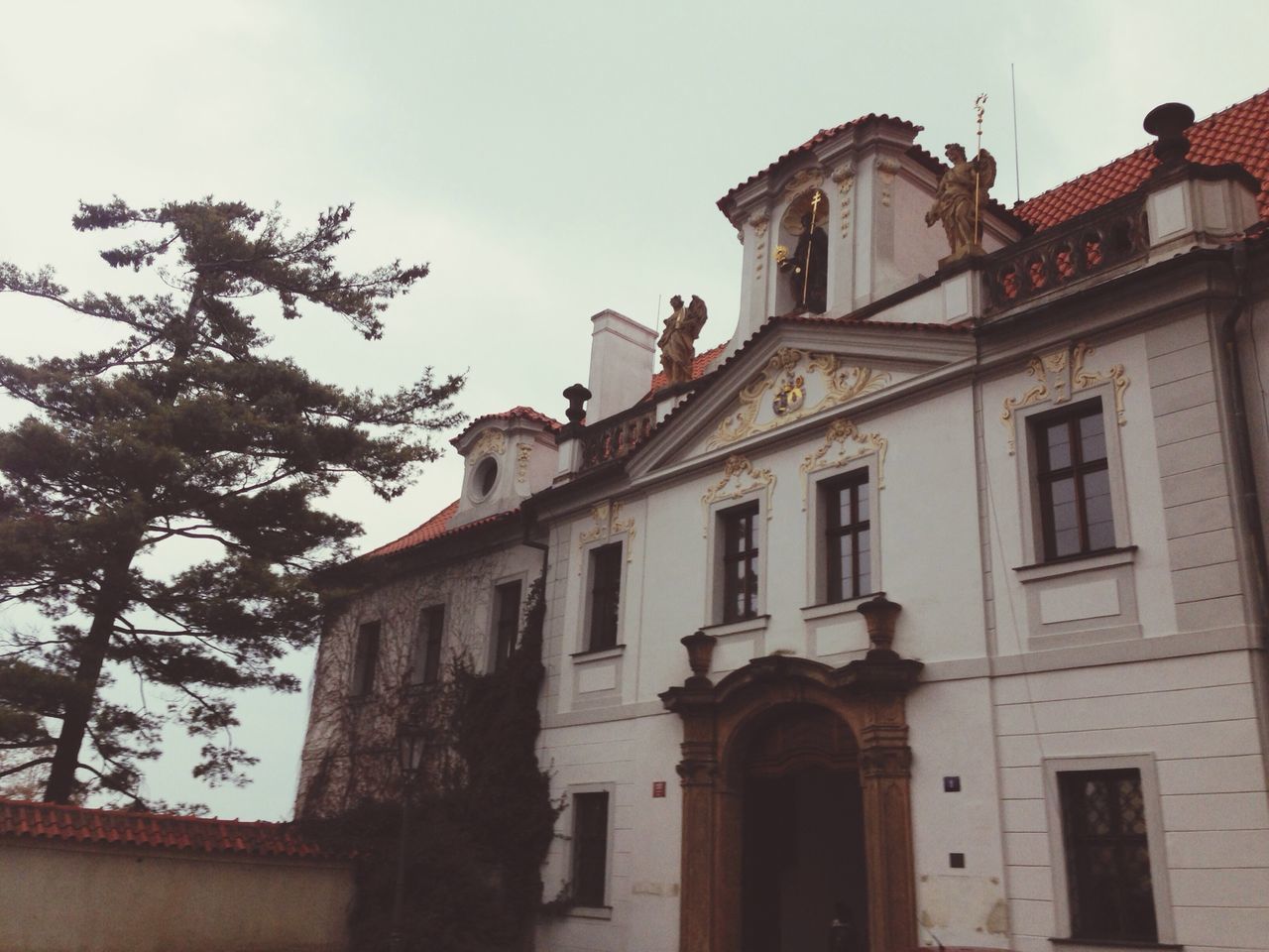 architecture, building exterior, built structure, low angle view, sky, window, building, residential building, residential structure, outdoors, house, day, no people, tree, high section, facade, old, cloud - sky, cloud, city