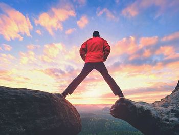 Man hiking in mountains, watching sunset and horizon over beautiful landscape. male hiker walking