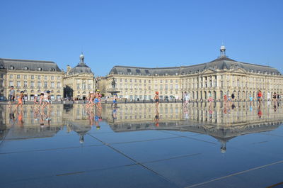 People at town square against buildings