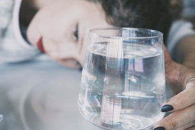 Close-up of hand holding glass of water