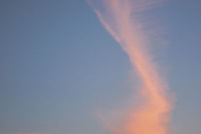 Low angle view of vapor trail in sky during sunset