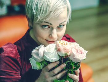 Close-up portrait of woman holding rose bouquet