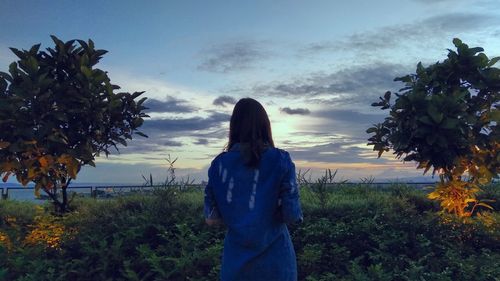 Woman standing on field against sky