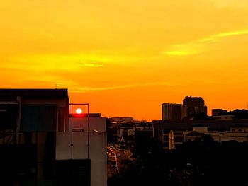 Illuminated cityscape against sky during sunset