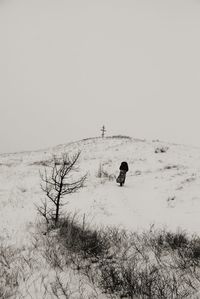 Man on snowy field against clear sky