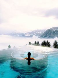 Man swimming in pool against sea